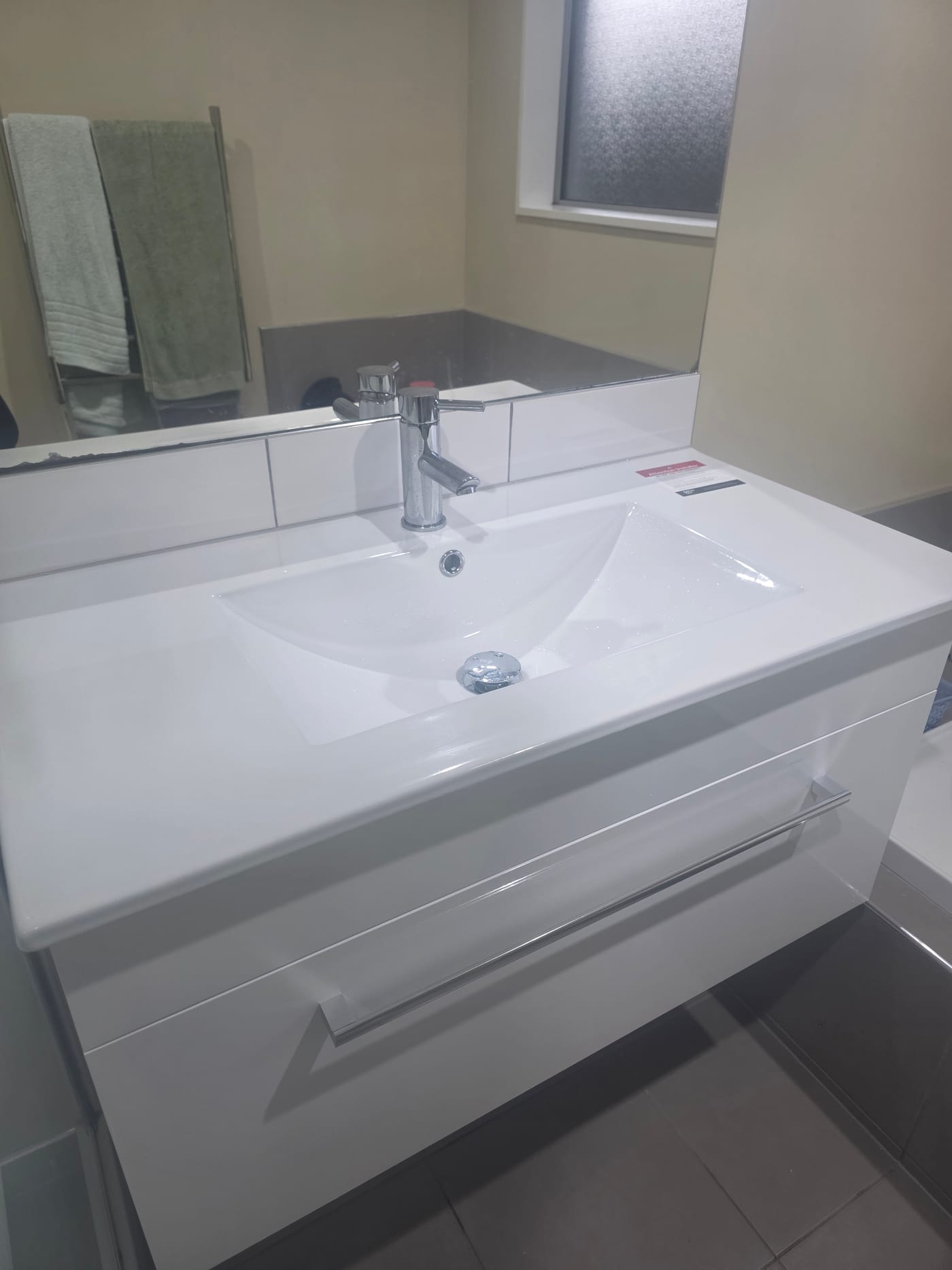 Newly installed wall-hung vanity and basin with chrome mixer tap
