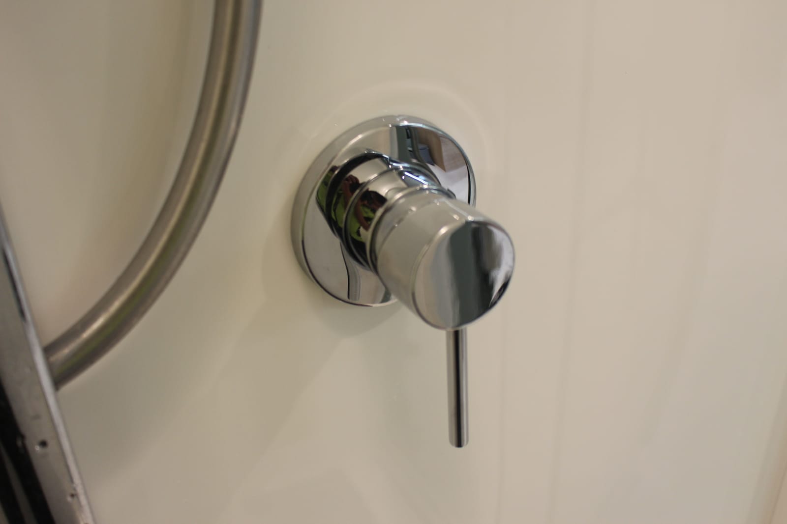 Close-up of a chrome shower mixer installed flush to the wall